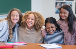 four girls at a table together smiling