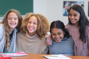 four girls at a table together smiling