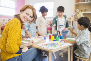 Teacher and students painting in classroom